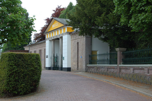 Een monumentale witgele poort geeft toegang tot de begraafplaats aan de Oldenzaalsestraat.
